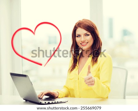 business, education and technology concept - smiling student with book laptop computer at school showing thumbs up