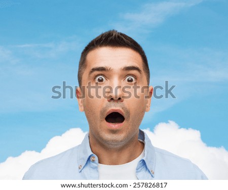fear, emotions, horror and people concept - scared man shouting over blue sky and cloud background