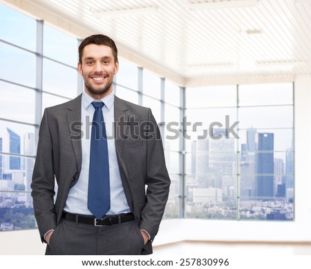 business, people and office concept - happy young businessman over office room or new apartment background