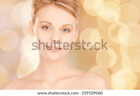 beauty, people and health concept - beautiful young woman face over beige lights background