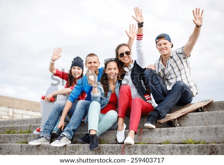 summer holidays and teenage concept - group of smiling teenagers hanging outside and waving hands