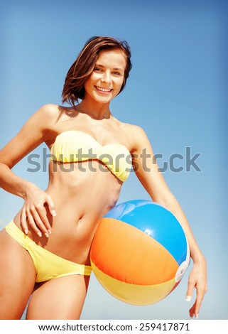 summer holidays, vacation and beach activities concept - girl in bikini with ball on the beach