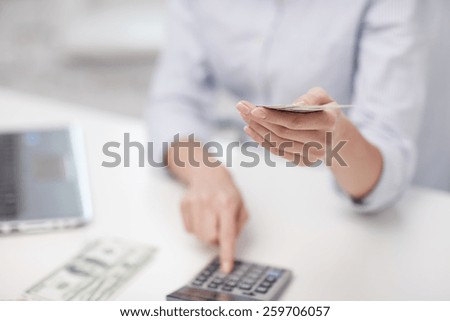 savings, finances, economy, technology and people concept - close up of woman counting money with calculator