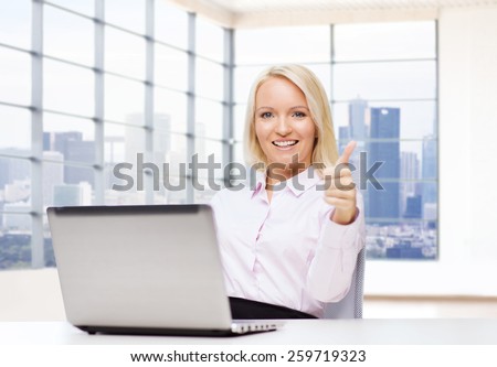 business, people, success, gesture and technology concept - smiling businesswoman or student showing thumbs up with laptop computer in office