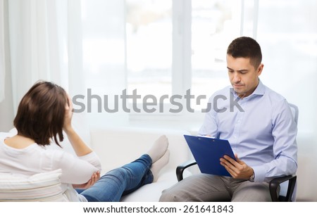 medicine, health care and people concept - doctor with clipboard and young woman meeting at home visit