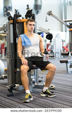 sport, fitness, equipment, lifestyle and people concept - man exercising on gym machine