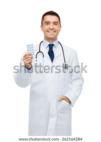 healthcare, profession, people and medicine concept - smiling male doctor in white coat with tablets