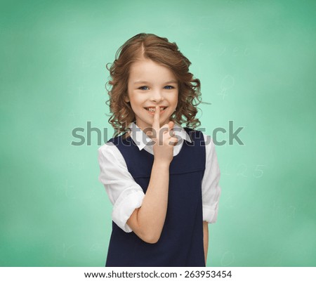 people, children, secrecy and mystery concept - happy girl showing hush gesture over green chalk board background
