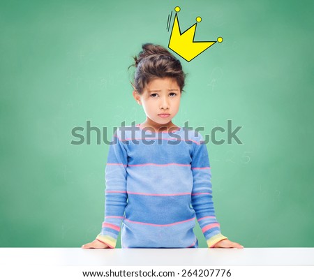 education, people, childhood and emotions concept - sad little school girl over green chalk board background and crown doodle
