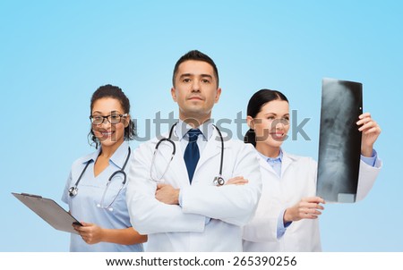 surgery, profession, people and medicine concept - group of medics with x-ray over blue background