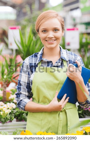 people, gardening, technology and profession concept - happy woman or gardener with tablet pc computer in greenhouse