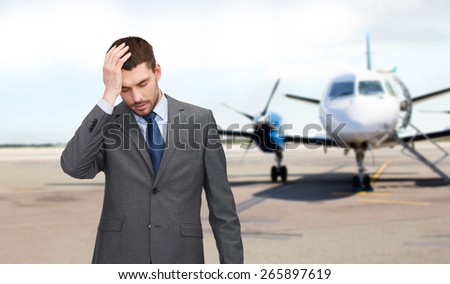 business, crisis, fail, people and travel concept - businessman having headache over airplane on runway background