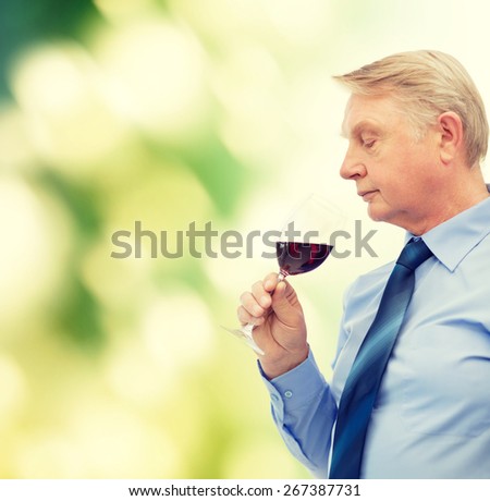 alcohol and beverage concept - elderly man smelling red wine
