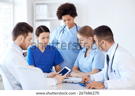 hospital, profession, people and medicine concept - group of doctors with tablet pc computers meeting at medical office
