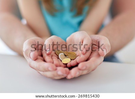 family, children, money, investments and people concept - close up of father and daughter hands holding euro money coins