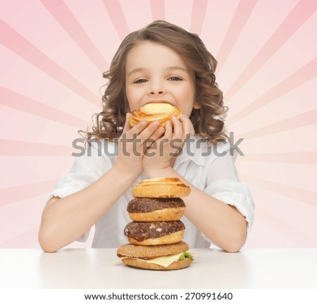 people, nutrition, childhood and health concept - happy little girl eating junk food over pink burst rays background