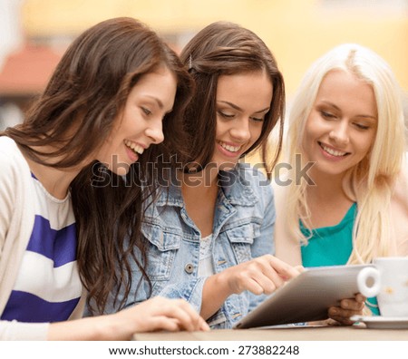 holidays, tourism, technology and internet - three beautiful girls looking at tablet pc computer in cafe outside