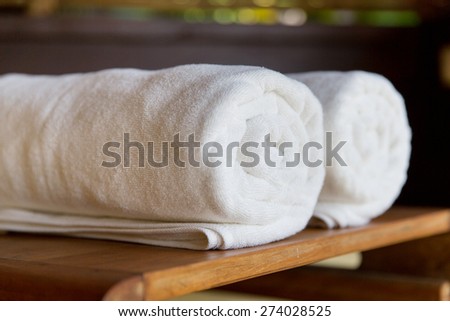 luxury and hygiene concept - rolled bath towels at hotel spa