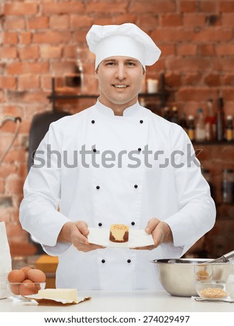 cooking, profession, haute cuisine, food and people concept - happy male chef cook baking dessert over kitchen background