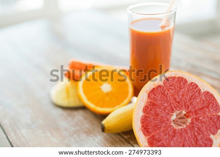 healthy eating, food and diet concept - close up of fresh juice glass and fruits on table