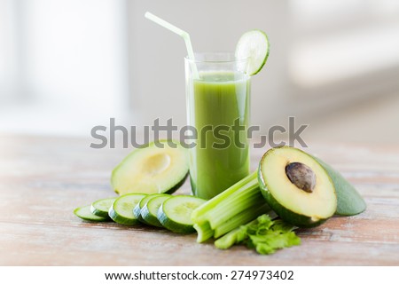 healthy eating, organic food and diet concept - close up of fresh green juice glass and vegetables on table