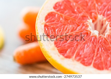 healthy eating, food, fruits and diet concept - close up of fresh juicy grapefruit slice on table