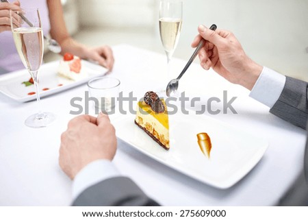 restaurant, food, people, date and holiday concept - close up of couple eating dessert at restaurant