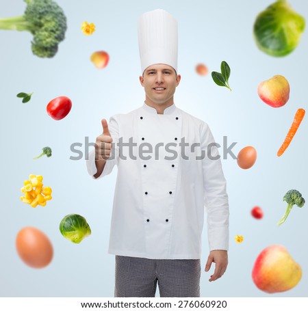 cooking, profession, gesture, vegetarian diet and people concept - happy male chef cook showing thumbs up over blue background with falling vegetables
