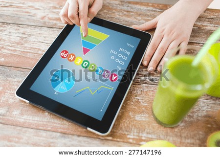 healthy eating, technology, diet and people concept - close up of woman hands with calories and vitamins chart on tablet pc, fresh juice