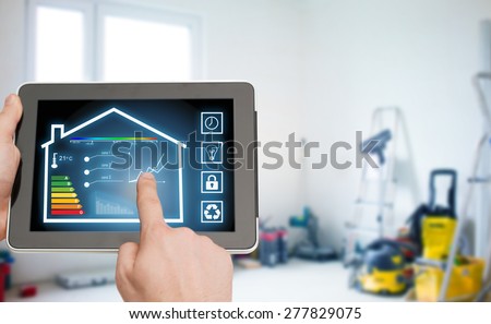 home, housing, people and technology concept - close up of man hands pointing finger to tablet pc computer and regulating room temperature over storeroom or building background
