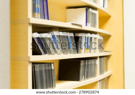 technology, storage and audio media concept - close up of shelving with cd records at recording studio or radio station