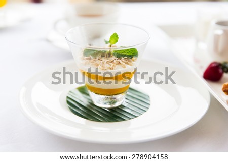 food, dessert, morning, breakfast and eating concept - close up of decorated milk dessert in glass on table at restaurant