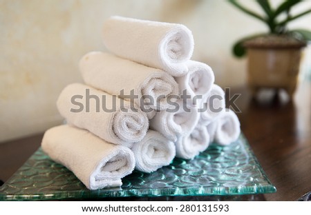 luxury and hygiene concept - rolled bath towels at hotel spa