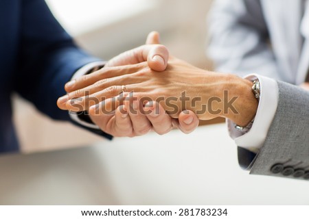 people, homosexuality, same-sex marriage and love concept - close up of happy male gay couple hands with wedding ring on