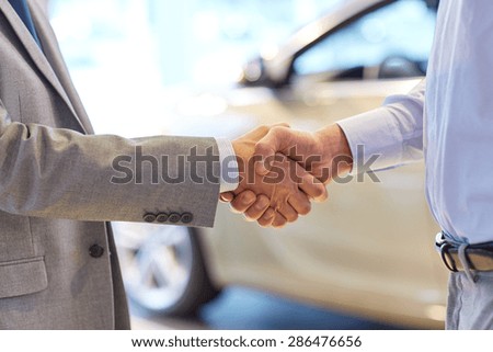 auto business, car sale, deal, gesture and people concept - close up of male handshake in auto show or salon
