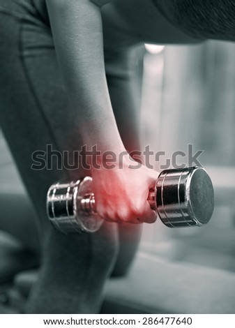 fitness, sport, sports injury, people and weightlifting concept - close up of young woman with dumbbells flexing muscles in gym