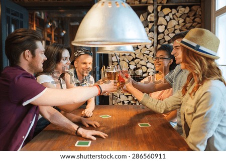 people, leisure, celebration and party concept - group of happy smiling friends clinking glasses with drinks at bar or pub