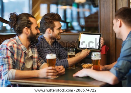 people, men, leisure, friendship and technology concept - happy male friends with tablet pc computer drinking beer at bar or pub