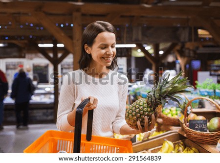 sale, shopping, consumerism and people concept - happy young woman with food basket in market