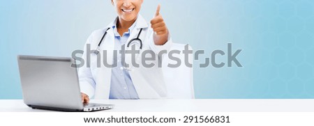 healthcare, medical and technology concept - happy african american female doctor with laptop pc computer showing thumbs up over blue background