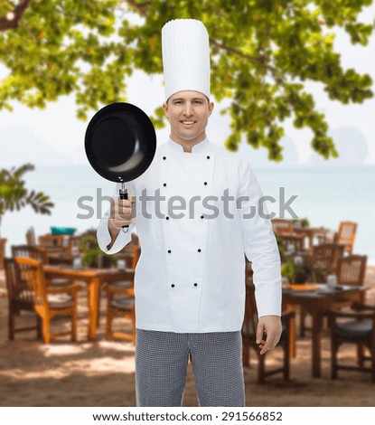 cooking, profession and people concept - happy male chef cook holding frying pan over restaurant lounge on beach