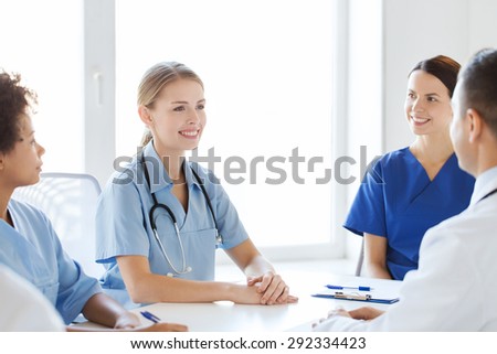 hospital, profession, people and medicine concept - group of happy doctors meeting and talking at medical office