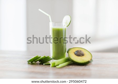 healthy eating, organic food and diet concept - close up of fresh green juice glass and vegetables on table