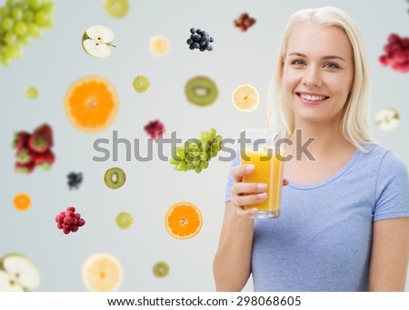 healthy eating, vegetarian food, dieting and people concept - smiling woman drinking orange juice or shake from glass over fruits and berries on gray background