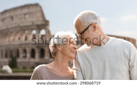 family, tourism, travel and people concept - happy senior couple over coliseum in rome, italy