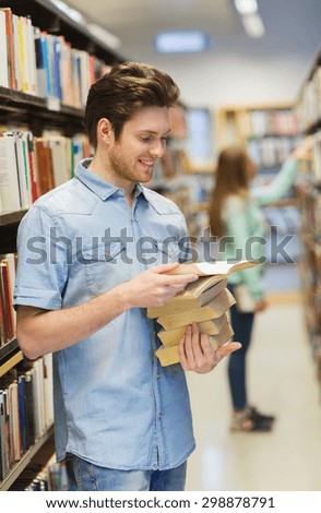 people, knowledge, education, literature and school concept - happy student or young man with book in library