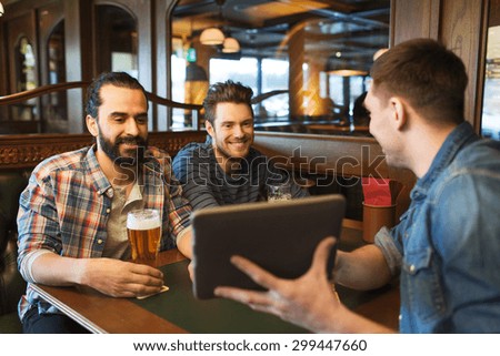 people, leisure, friendship, technology and bachelor party concept - happy male friends with tablet pc computer drinking beer at bar or pub