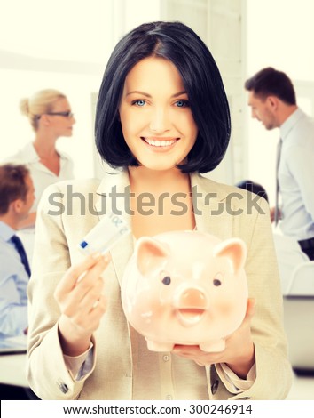 business and money saving concept - woman with piggy bank and cash money