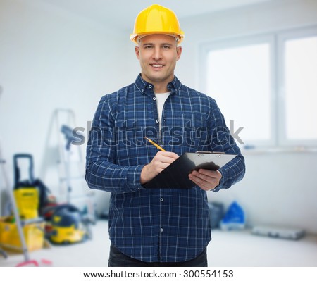 repair, construction, building, people and maintenance concept - smiling male builder or manual worker in helmet with clipboard taking notes over room with work equipment background