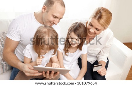 family, online shopping, technology and people - happy family with tablet pc computer and credit card at home